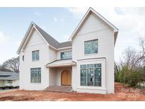 Stately two-story home showcasing a brick facade, arched front door, and large windows providing an abundance of natural light at 410 Wingrave Dr, Charlotte, NC 28270