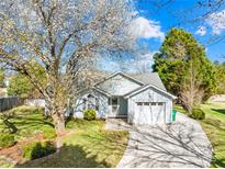 Charming single-Gathering home featuring a well-manicured lawn and a blossoming tree in a suburban neighborhood at 6325 Martin Lake Rd, Charlotte, NC 28227