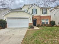 Charming two-story home with a two-car garage, brick accents, and a well-maintained front lawn at 10927 Kinnairds St, Charlotte, NC 28278