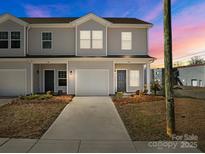 Charming townhome featuring a one car garage, neutral siding, and well manicured landscaping at 136 S Bell Ave, Albemarle, NC 28001