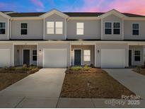Charming townhomes with attached garages and inviting curb appeal under a colorful sky at 138 S Bell Ave, Albemarle, NC 28001