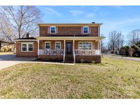 Charming two-story brick home with a welcoming front porch and well-maintained lawn at 305 Plantation Dr, Kings Mountain, NC 28086