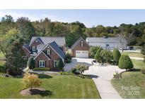 Expansive brick home with a lush lawn, oversized driveway, detached garage and additional parking space at 3099 Trinity Church Rd, Concord, NC 28027