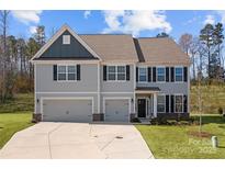 Charming two-story home with a two-car garage, manicured lawn, and classic architectural details at 3212 Burnello Ct, Iron Station, NC 28080