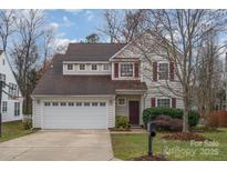Charming home features a two-car garage, dormer windows, and mature landscaping at 3612 Brookstone Trl, Indian Trail, NC 28079