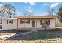 Charming white brick home featuring a covered front porch with rocking chairs at 4083 Hord Rd, Sharon, SC 29742