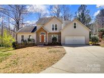 Charming home with stone accents, a two-car garage, and a well-manicured front yard at 7306 Timbercreek Ct, Denver, NC 28037