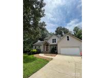 Inviting traditional two-story home featuring a two-car garage, stone accents, and a meticulously landscaped front yard at 7306 Timbercreek Ct, Denver, NC 28037