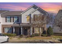 Charming townhome featuring brick accents, neutral siding, a well-maintained lawn and a colorful sunset backdrop at 10530 Stoneacre Ct, Pineville, NC 28134