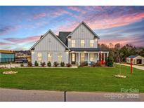 Inviting two-story home with manicured lawn, charming front porch, and patriotic American flag displayed at 135 Goldenrod Cir, Salisbury, NC 28147