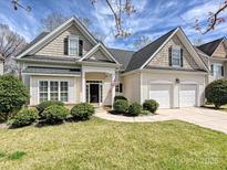 Charming two-story home with a well-manicured lawn, attached two-car garage, and classic design elements at 1394 Fitzgerald Nw St, Concord, NC 28027