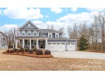 Charming two-story home featuring a welcoming front porch and a three-car garage at 158 Country Lake Dr, Mooresville, NC 28115