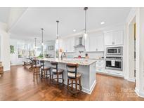 Bright kitchen features a large center island with bar seating and modern stainless steel appliances at 158 Country Lake Dr, Mooresville, NC 28115