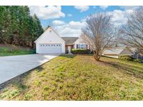 Charming home featuring an attached two-car garage, white siding, and a well-maintained front yard with lush greenery at 2359 Eagle Glen Ct, Gastonia, NC 28056