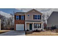Charming two-story home with a brick accent, covered porch, and well-maintained landscaping at 299 Berrybeth Cir, China Grove, NC 28023