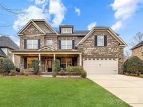 Beautiful two story brick home featuring an attached two car garage, manicured lawn and covered front porch at 4624 Pebble Run Dr, Matthews, NC 28105