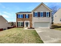 Charming two-story home featuring a brick facade, black shutters, and a well-manicured lawn at 5810 Dove Point Sw Dr, Concord, NC 28025
