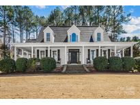 Charming home with a welcoming front porch, manicured landscaping and a symmetrical facade at 607 Beaten Path Rd, Mooresville, NC 28117