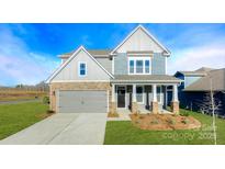 Charming two-story home with a manicured lawn, stone accents, and a welcoming front porch at 7021 Sylvan Retreat Dr, Denver, NC 28037