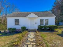 Charming single-story home with white siding, walkway, and landscaped front yard under a clear blue sky at 826 E Alexander St, Lincolnton, NC 28092