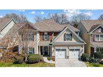 Charming two-story home featuring a two-car garage, stone accents, and manicured landscaping at 10153 Elizabeth Crest Ln, Charlotte, NC 28277