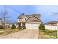 Inviting two-story home with a two car garage, well-maintained lawn, and a welcoming porch at 10605 Three Rivers Ct, Charlotte, NC 28273