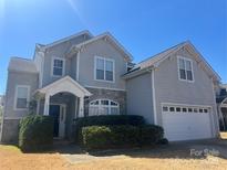 Charming two-story home with attached garage, attractive stone accents and manicured landscaping at 10933 Sedgemoor E Ln, Charlotte, NC 28277