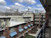 Apartment building with brick facade, courtyard with manicured greenery, and Charlotte skyline views at 1101 W 1St St # 410, Charlotte, NC 28202