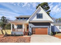 Charming two-story home with a modern garage, inviting porch, and freshly landscaped yard at 1210 Skyview Rd, Charlotte, NC 28208