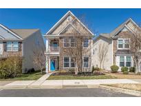 Charming two-story home featuring a stone facade, a blue front door, and a small balcony at 13925 Helen Benson Blvd, Davidson, NC 28036