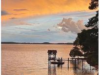 Peaceful lake view with covered dock at dusk at 17811 Half Moon Ln # C, Cornelius, NC 28031