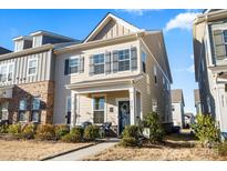 Charming two-story home with gray shutters, covered front porch, and lush landscaping at 2147 Stevens Mill Rd, Matthews, NC 28104