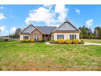Charming single-story home with stone accents, blue shutters, and beautifully landscaped front yard at 255 Dorothy Dr, China Grove, NC 28023