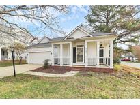 Charming one-story home featuring a covered front porch with classic white columns and manicured landscaping at 2702 Robyns Glen Dr, Charlotte, NC 28269
