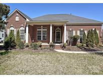 Charming brick home featuring a manicured front yard and a welcoming front porch with classic columns at 315 Drake Park Ave, Fort Mill, SC 29708