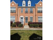 Charming brick townhome with tidy landscaping, gray entry door, and black iron balcony details at 3812 York Aly, Lake Park, NC 28079