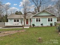 Charming home featuring a red front door, inviting porch, and well-manicured lawn at 5091 Windward Dr, Tega Cay, SC 29708