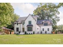 Stunning white painted brick home featuring black-trimmed windows and a perfectly manicured front lawn at 5124 Lansing Dr, Charlotte, NC 28270