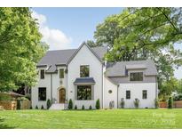 Stunning white brick home featuring lush front yard, arched front door and well-manicured landscaping at 5124 Lansing Dr, Charlotte, NC 28270