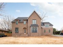 Elegant brick home featuring black framed windows, a charming arched entryway, and a classic gabled roof design at 5124 Lansing Dr, Charlotte, NC 28270