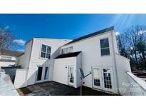 Exterior view of a well-maintained two-story home with white siding and a manicured yard against a blue sky at 7138 Stonington Ln, Charlotte, NC 28227