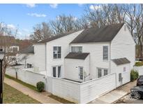 Charming two-story townhouse featuring white siding, a fenced patio, and well-maintained landscaping at 7138 Stonington Ln, Charlotte, NC 28227