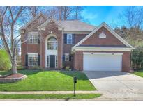 Charming two-story brick home featuring a manicured lawn and attached two-car garage at 8414 Bampton Dr, Concord, NC 28027