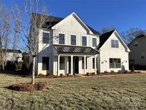 A beautiful two-story home featuring a white exterior, black roof, and a well-maintained front yard at 8827 Wingard Rd, Waxhaw, NC 28173