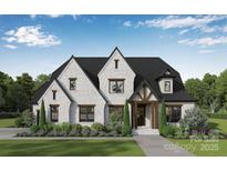 Charming two-story home with white brick, dark roof, manicured lawn and lush landscaping at 106 Pecan Cove Ln, Weddington, NC 28104