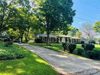 Beautiful brick home with a covered front porch and a well-manicured lawn with large mature trees at 1111 Ladell Ln, Shelby, NC 28152