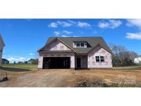 New construction home featuring a two-car garage and dormer window with gray shingles at 11533 Valley Oaks Ln, Stanfield, NC 28163