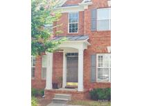 Charming brick home featuring a covered entryway with white columns and grey shutters at 11609 Mersington Ln, Charlotte, NC 28277