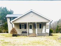 Charming two-story home featuring a covered front porch and metal roof on a large lawn at 1174 Trexler Rd, Salisbury, NC 28146