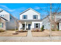 Charming two-story home with white siding, gray accents, and a well-manicured front lawn at 12425 Larue Ln, Huntersville, NC 28078